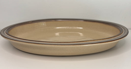Ceramic plate with a brown rim on a white background