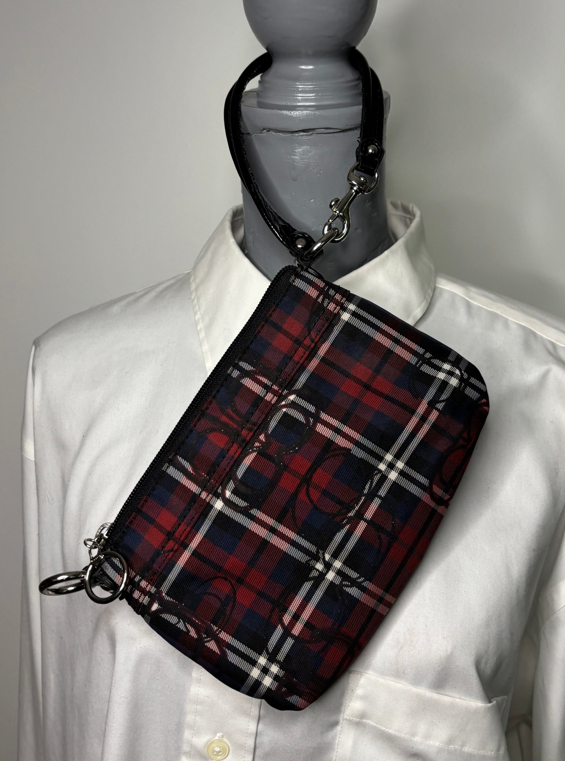 Plaid bag on a mannequin wearing a white shirt against a gray background