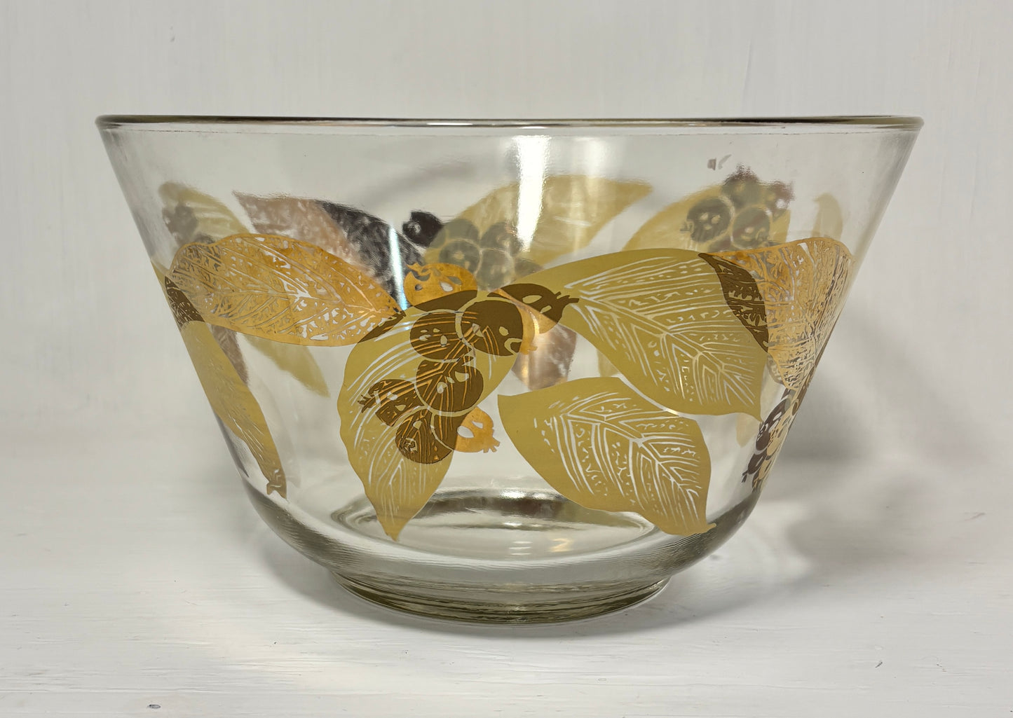 Clear glass bowl with gold leaf pattern on a white background