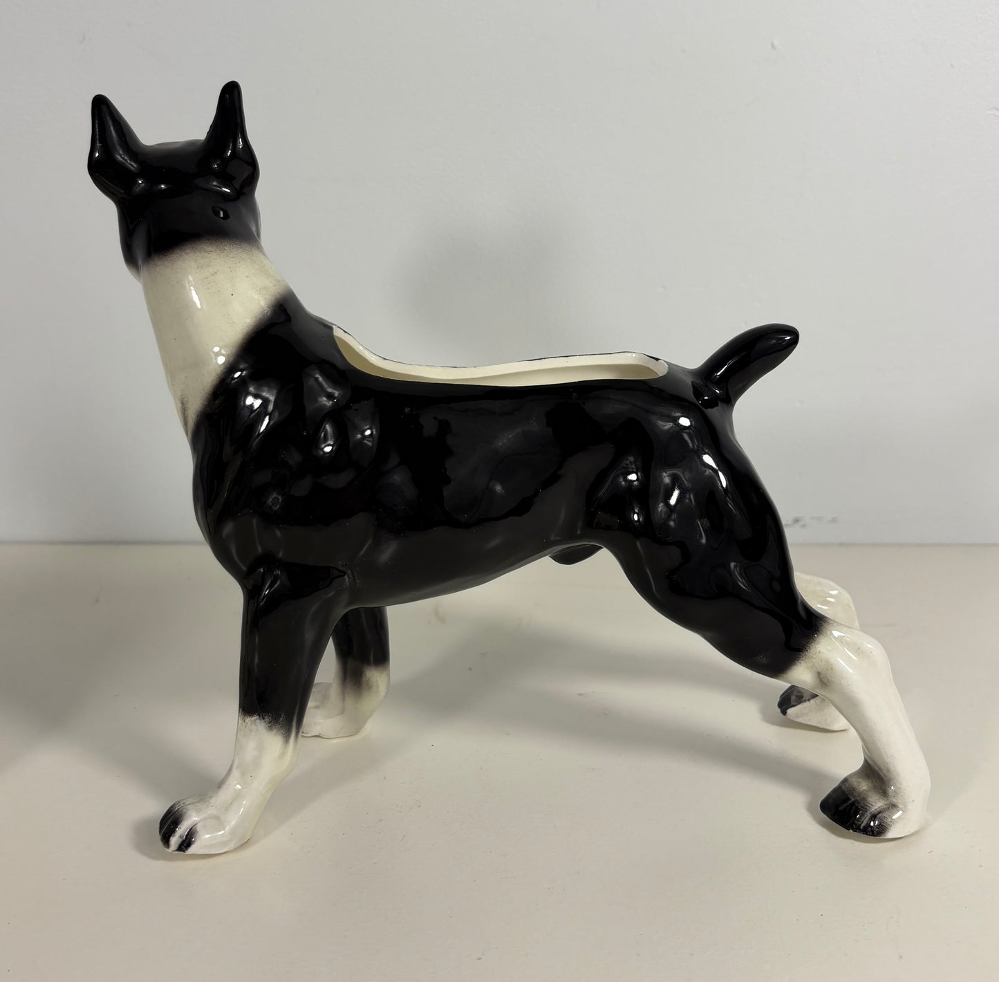 Ceramic dog-shaped planter with black and white design on a plain background