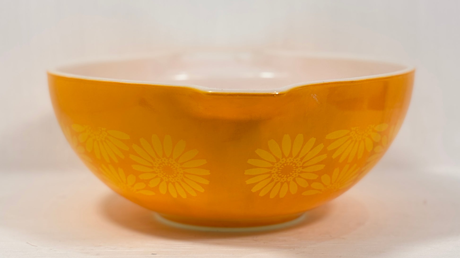 Orange bowl with yellow floral patterns on a white background