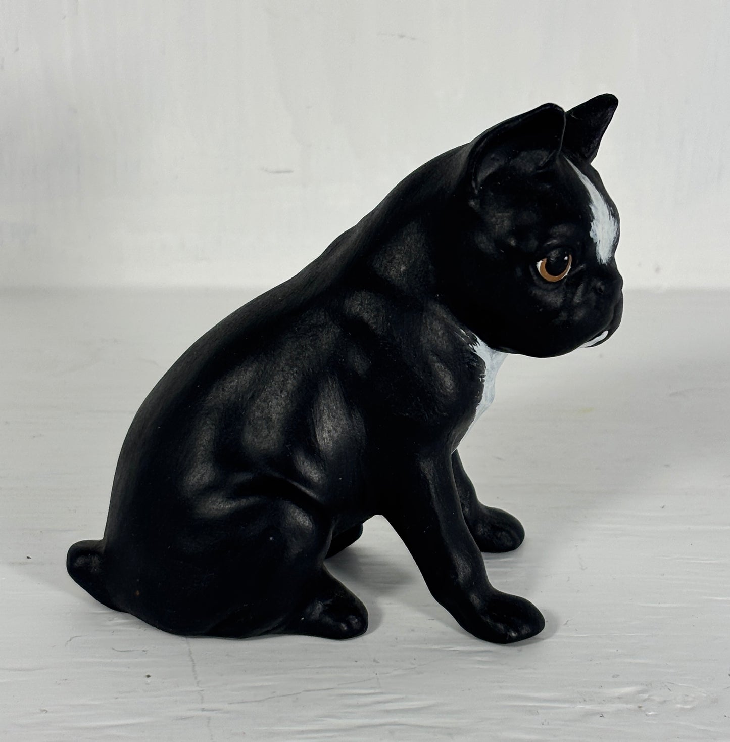 Black and white dog figurine on a light wooden floor