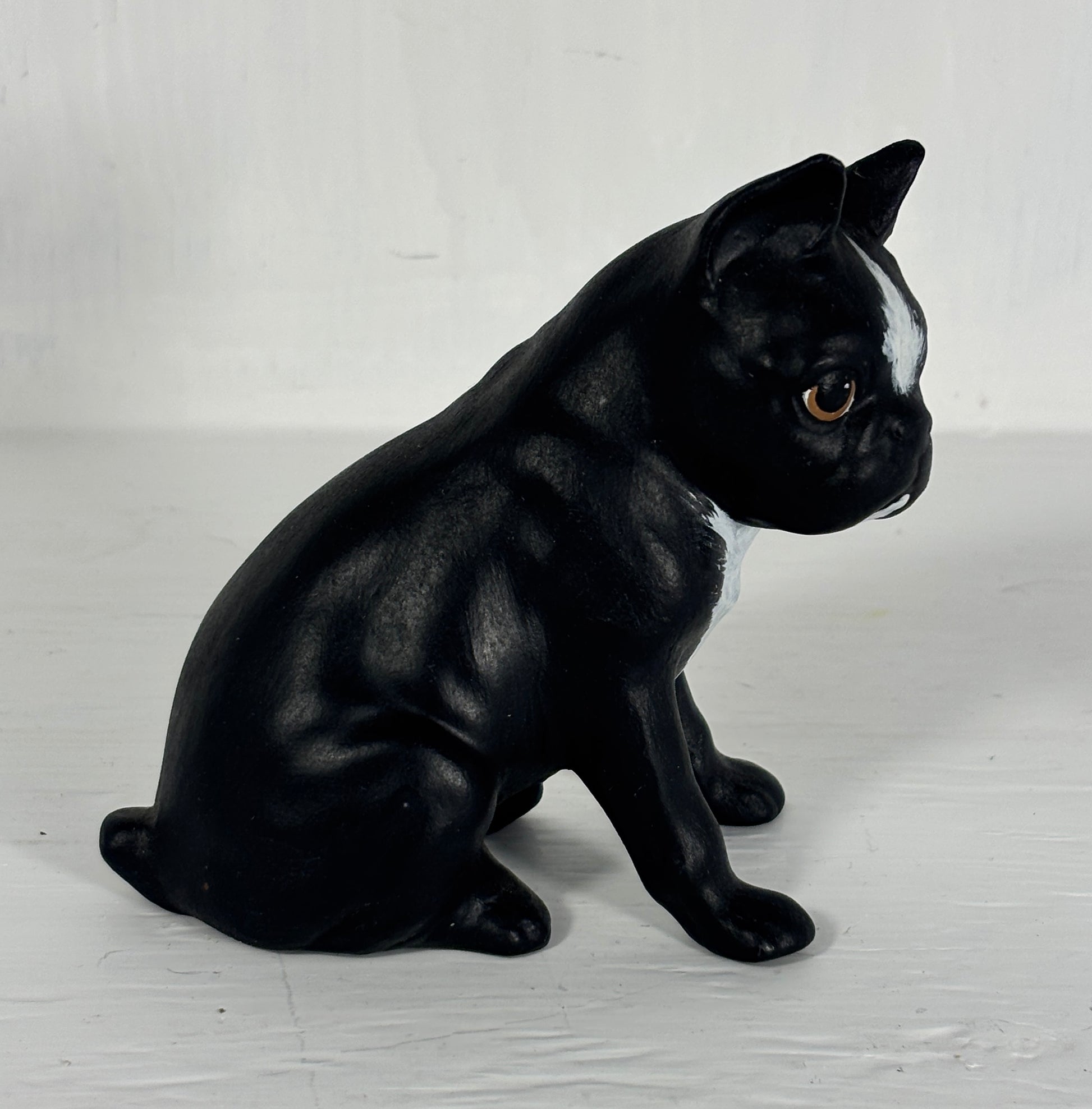 Black and white dog figurine on a light wooden floor