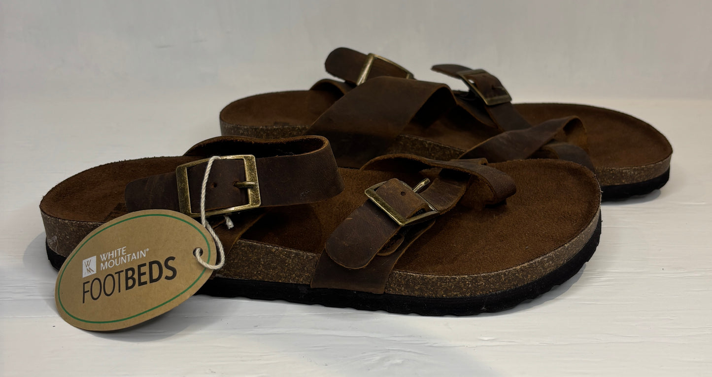 Brown sandals with a visible brand tag on a white background