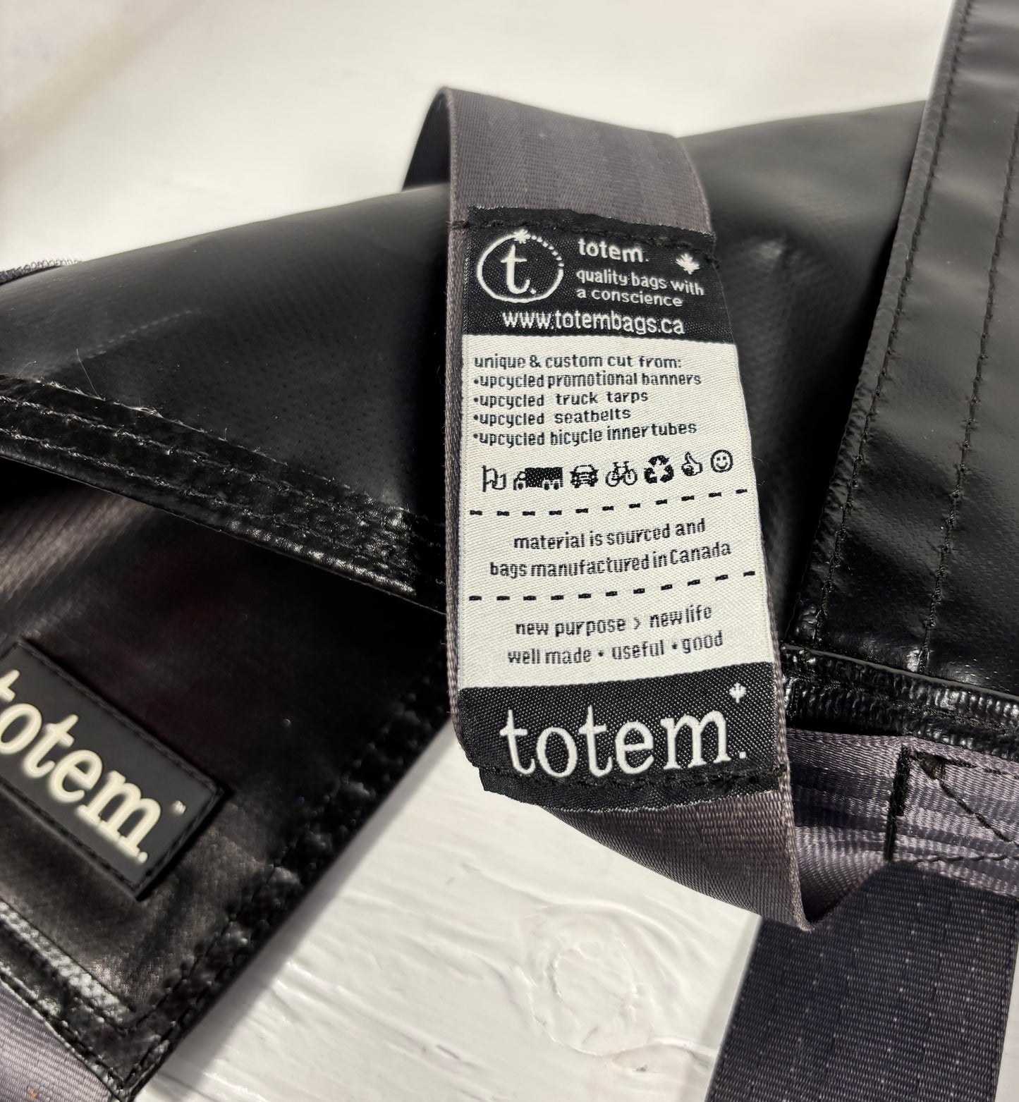 Close-up of a 'totem' brand label on a black bag.