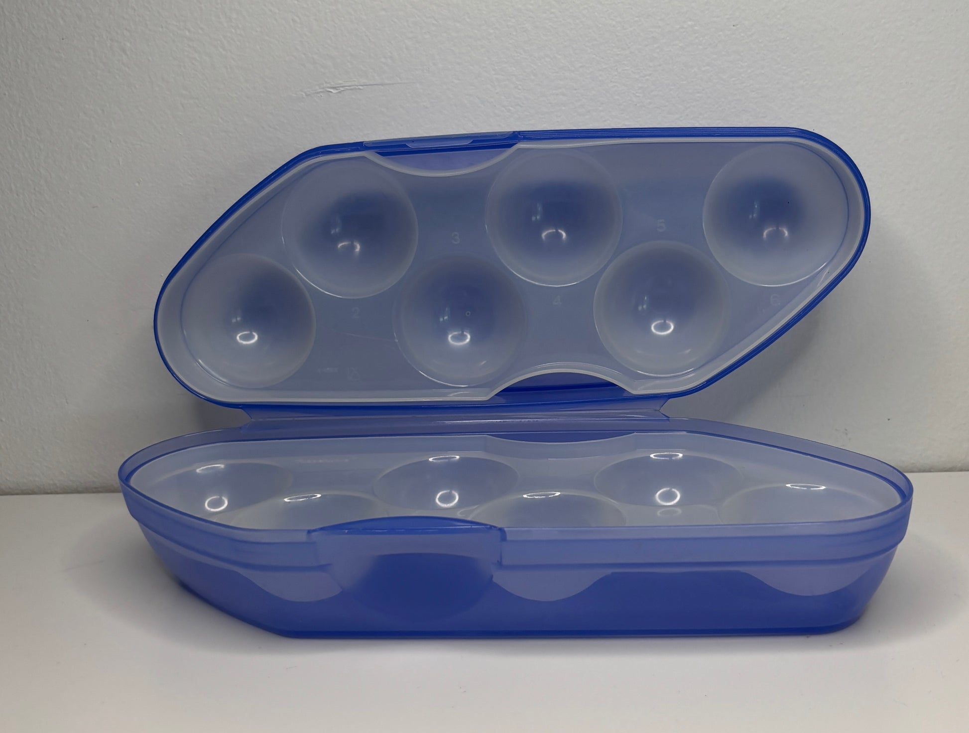 Blue plastic container with clear lid on a white background