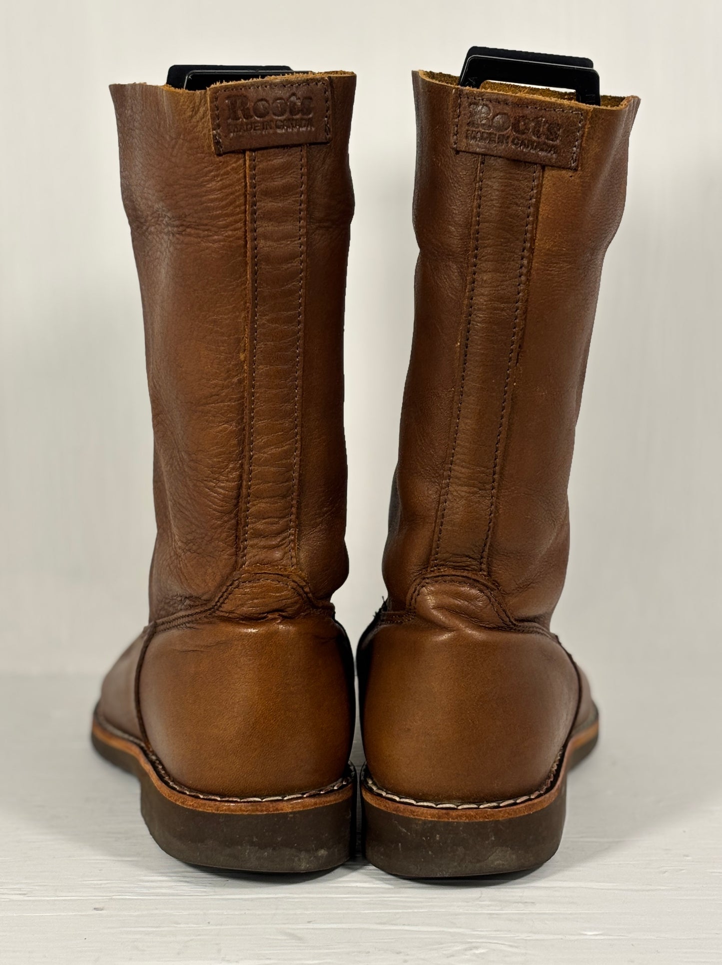 Pair of brown leather boots on a light gray background