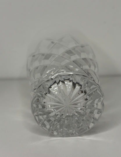 Crystal bottle with cut design on a plain background