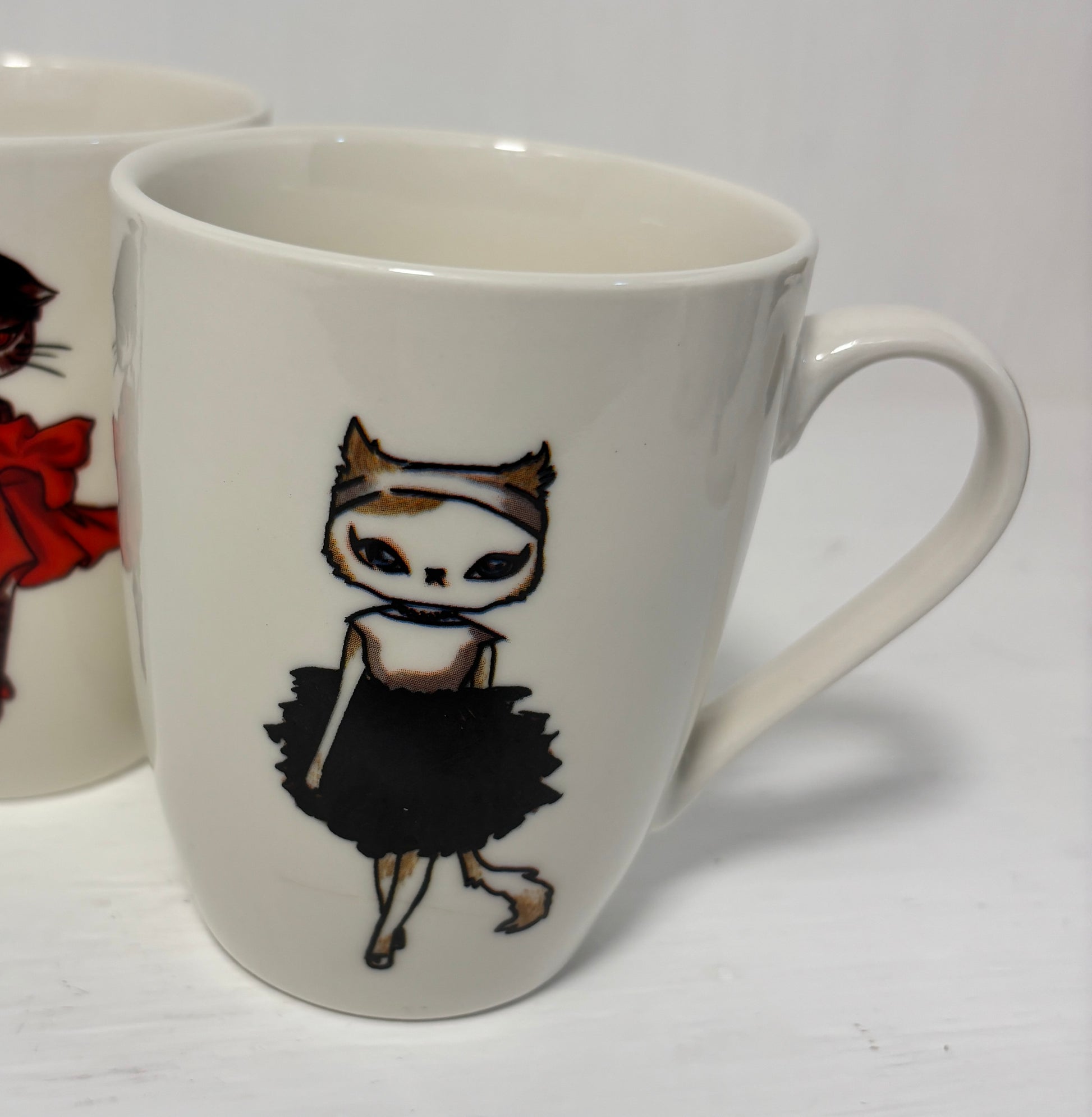 White mug with a decorative design of a cat in a black dress on a white background