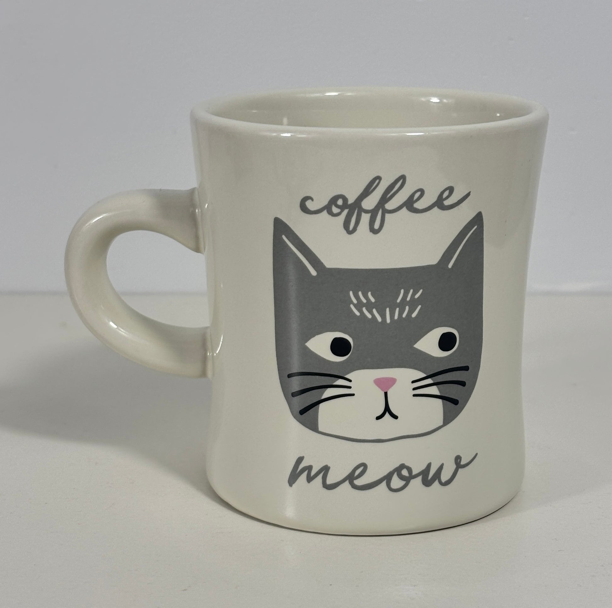 Mug with a cat face design and 'coffee meow' text on a white background