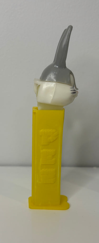 Yellow toy with a gray and white cat-like figure on a white background