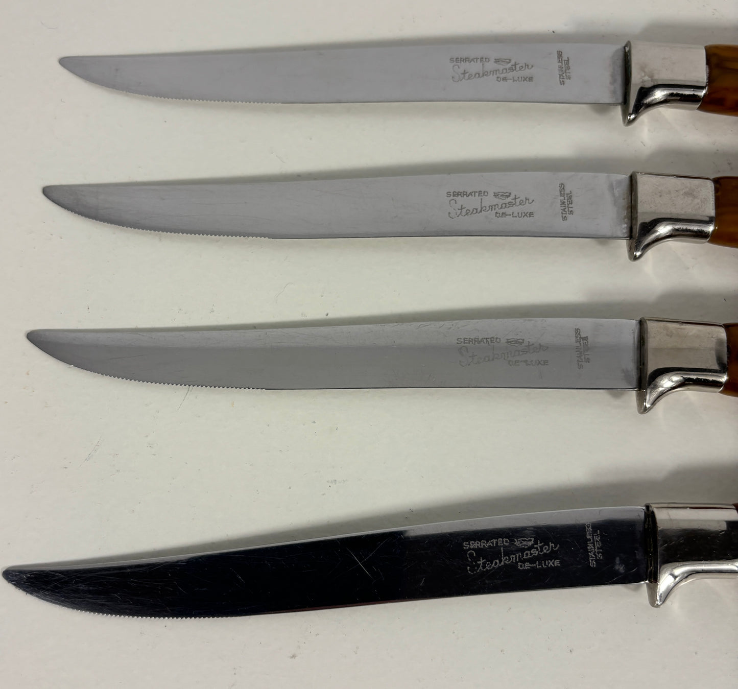 Set of four knives with wooden handles on a white background