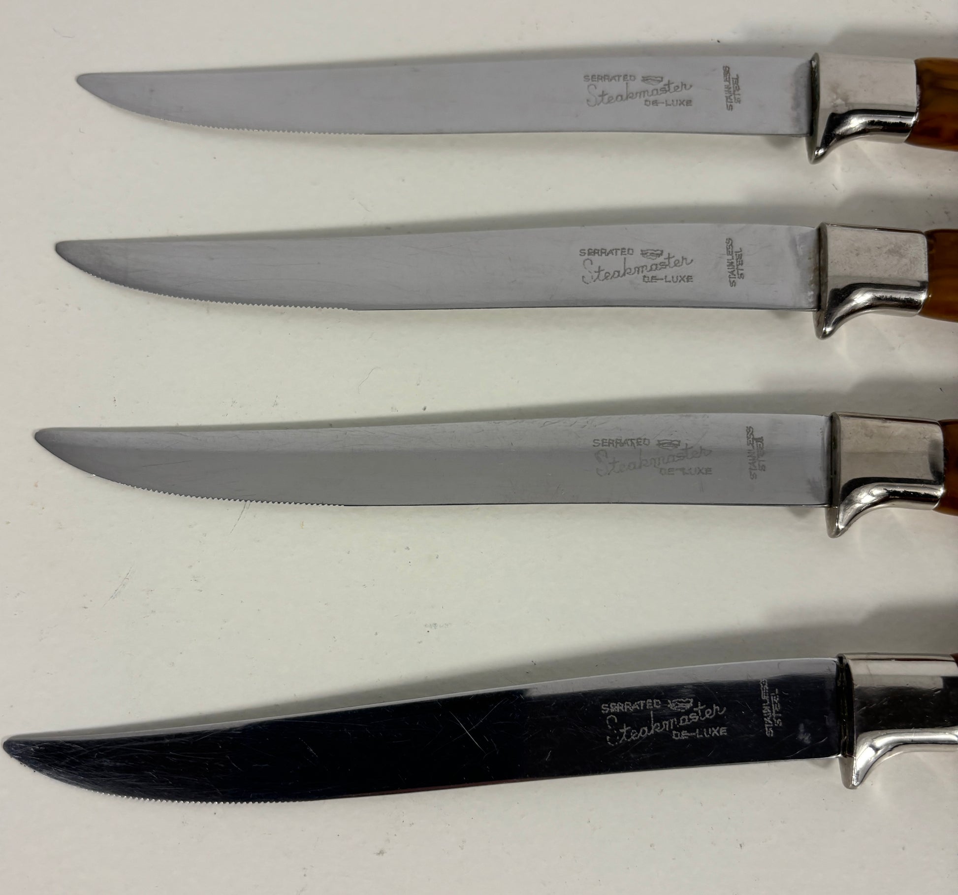 Set of four knives with wooden handles on a white background