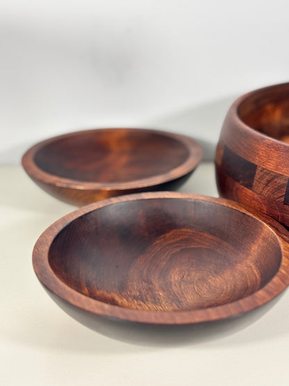 Three wooden bowls of varying sizes on a light background