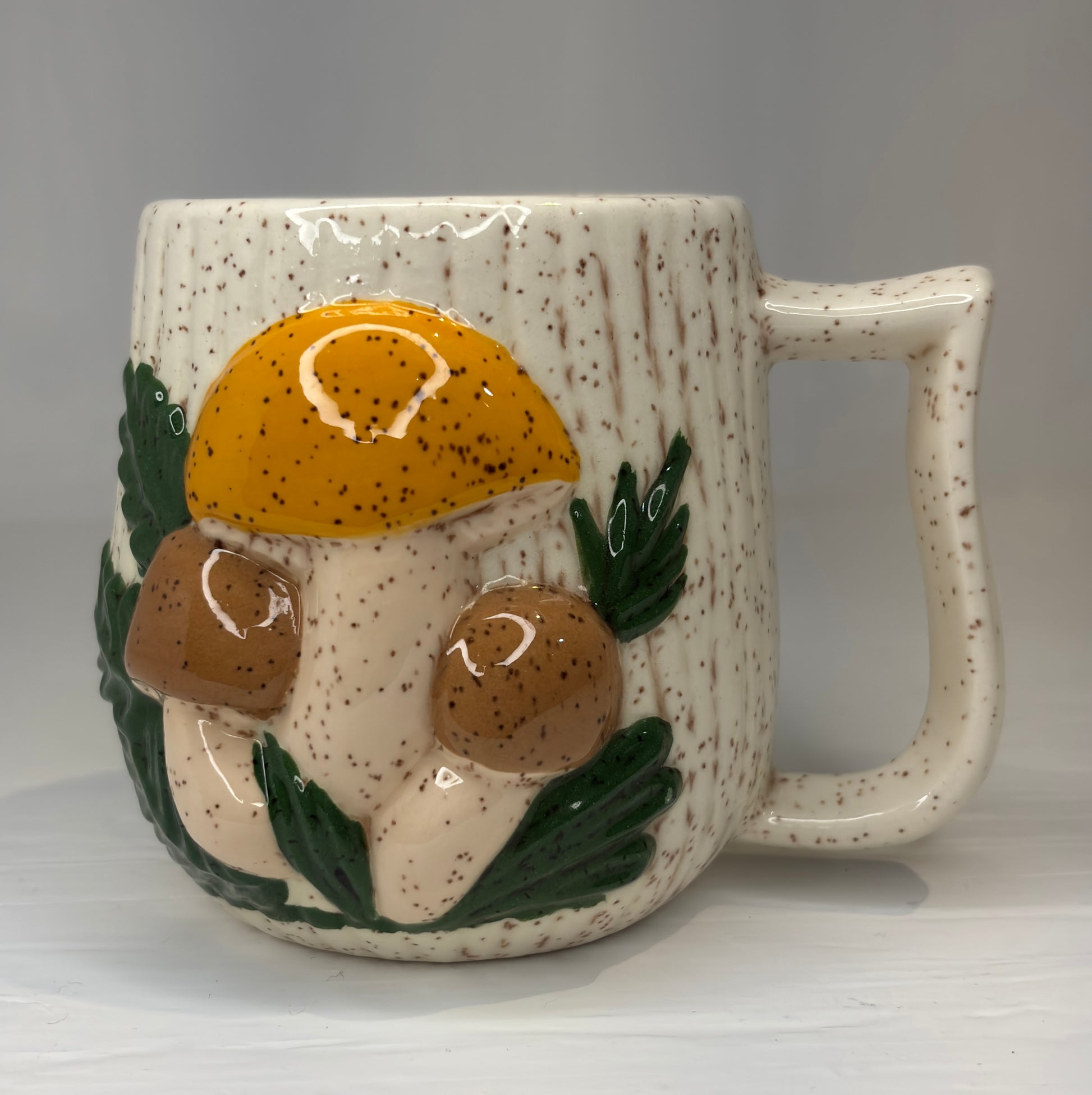 Ceramic mug with mushroom design on a gray background