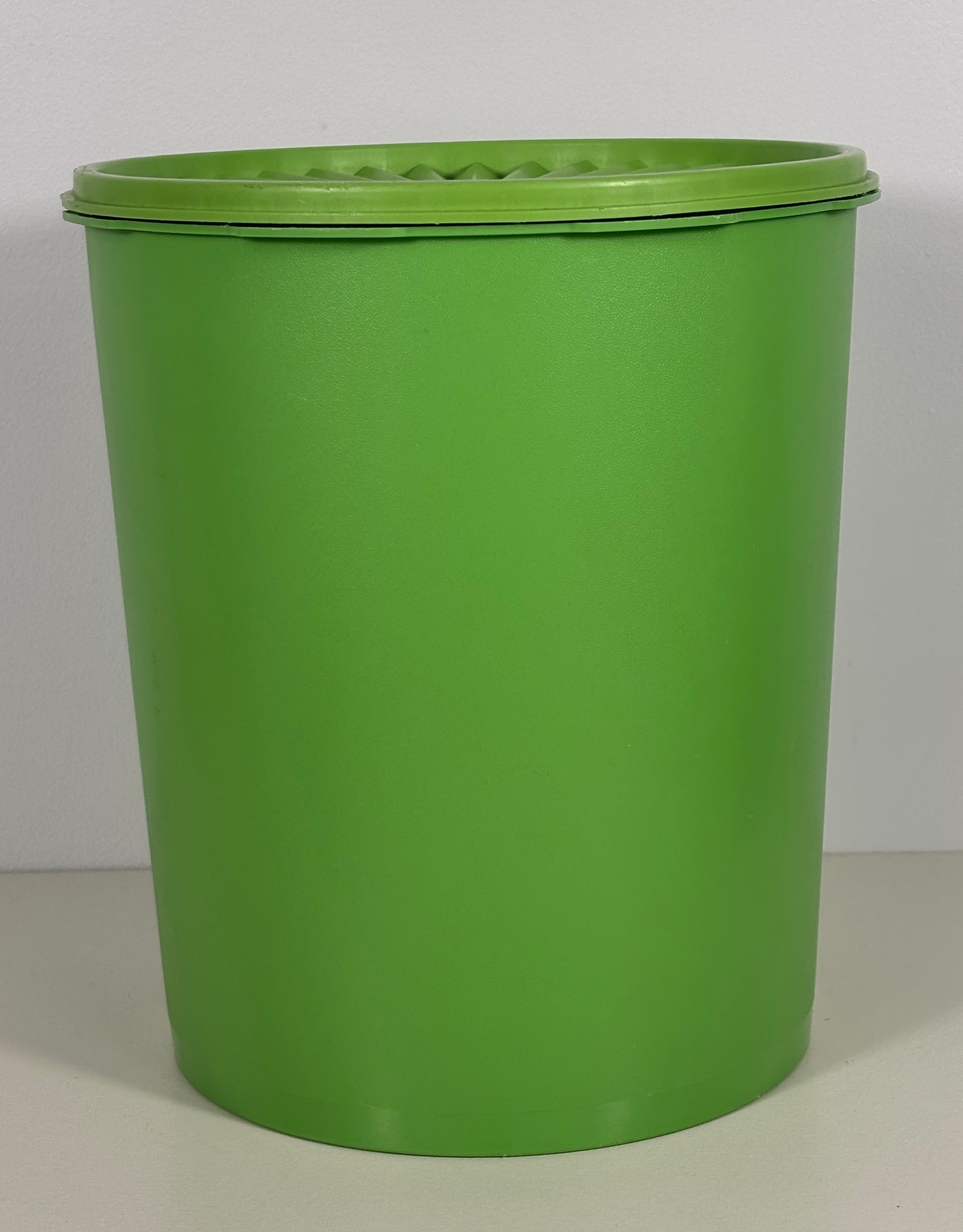 Green plastic container with a lid on a gray background