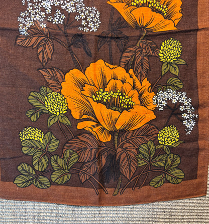 Floral design with orange flowers and green leaves on a brown background