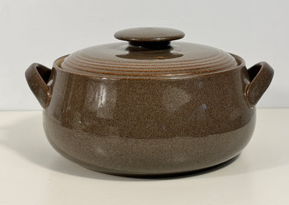 A brown ceramic lidded casserole pot with two side handles, shown on a plain white background.
