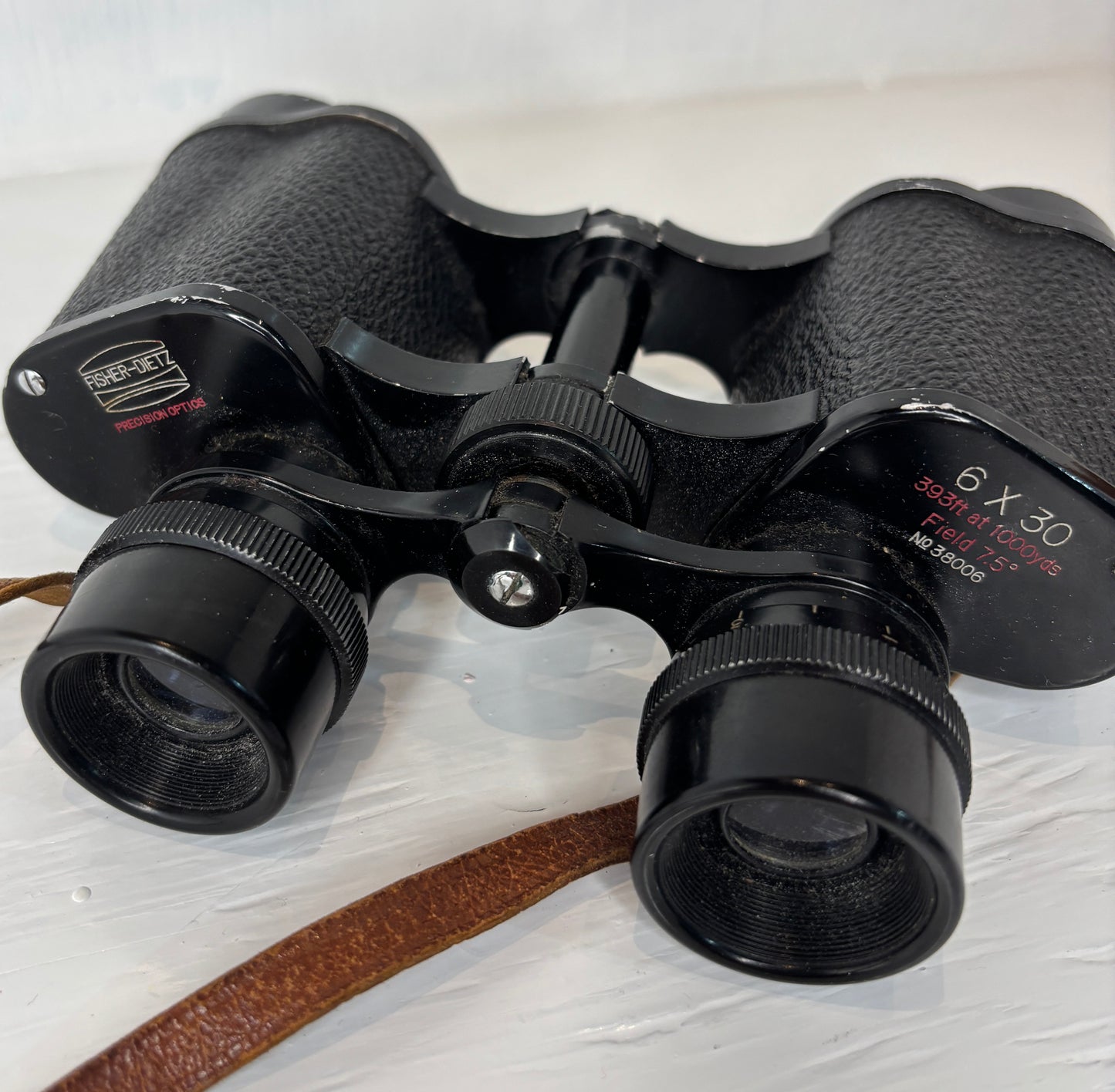 Black binoculars with brand name on a light wooden surface