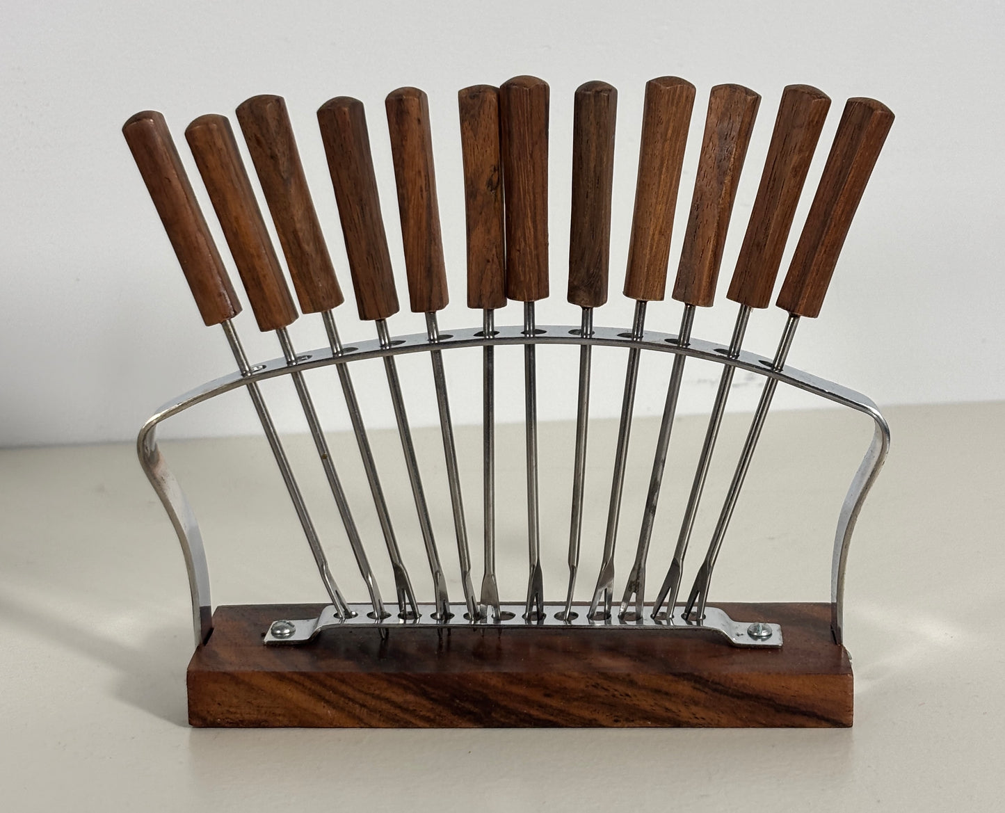 Wooden and metal skewer holder on a white background