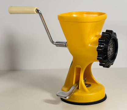 Yellow manual grinder with a black gear on a light background
