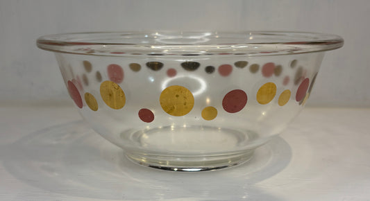 Clear glass bowl with colorful polka dot pattern on a white background