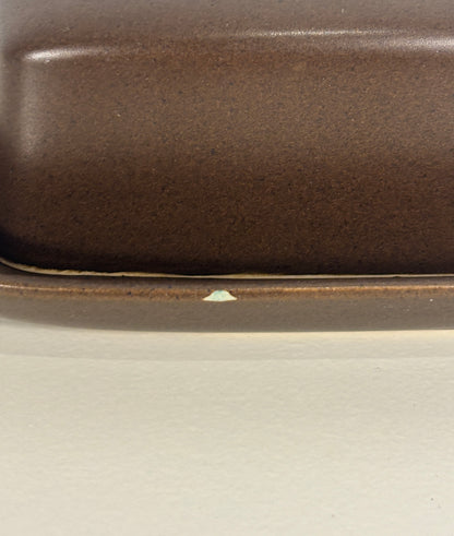 Close-up of a brown ceramic dish on a light gray background