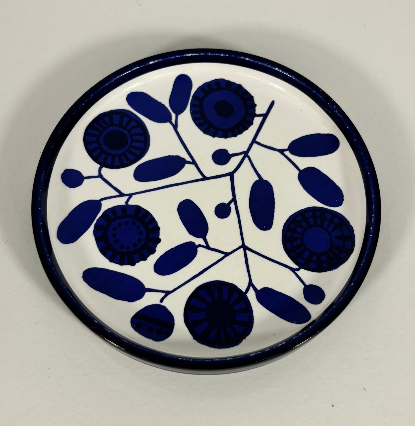 Round ceramic plate with blue floral pattern on a white background
