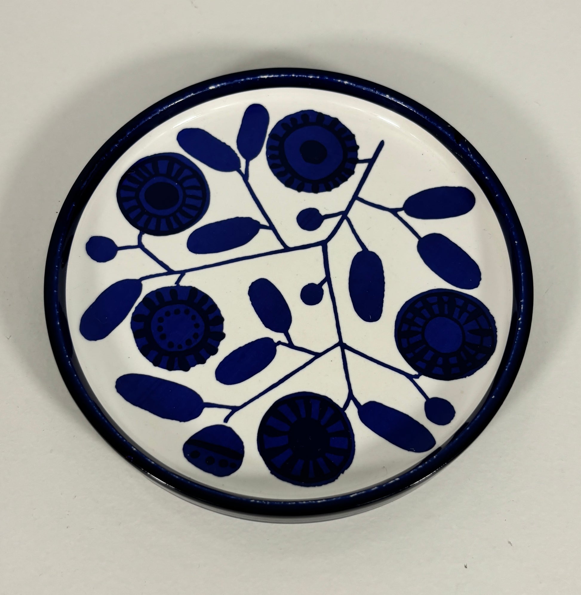 Round ceramic plate with blue floral pattern on a white background