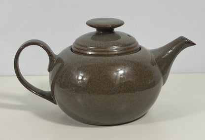 A brown speckled ceramic teapot with a matching lid, shown on a plain light background.