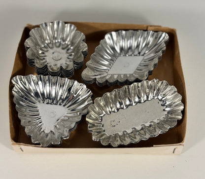 Set of silver metal tart tins in a cardboard box on a white background