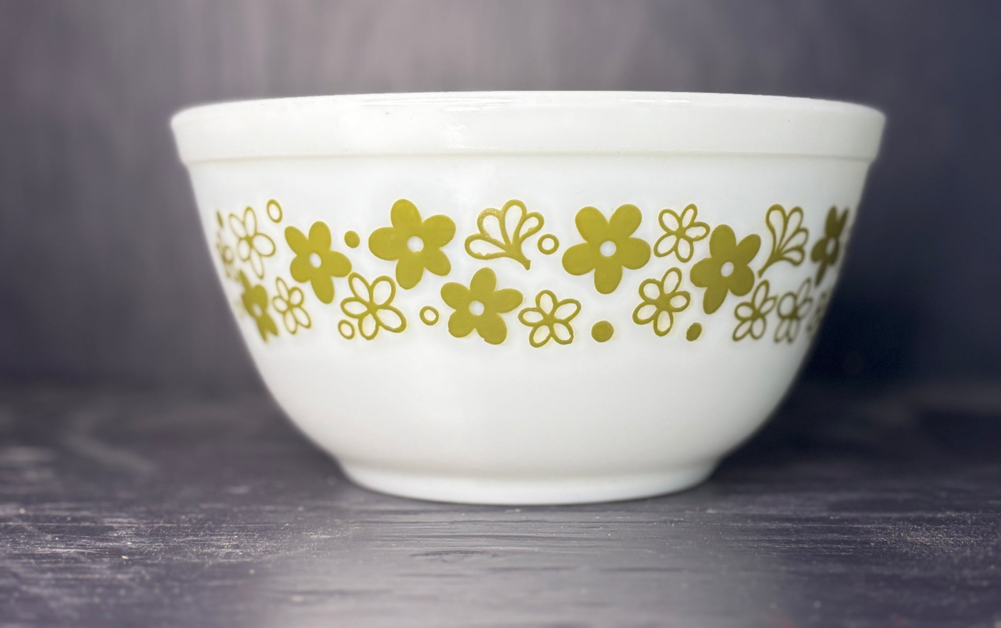 White bowl with gold floral pattern on a dark surface
