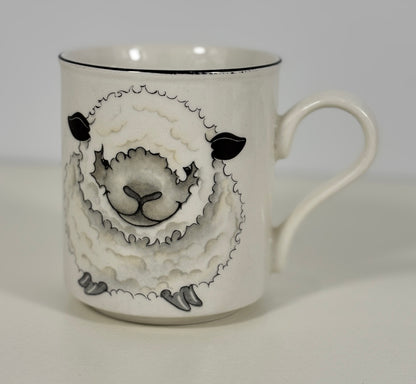 White mug with black and gray sheep design on a white background