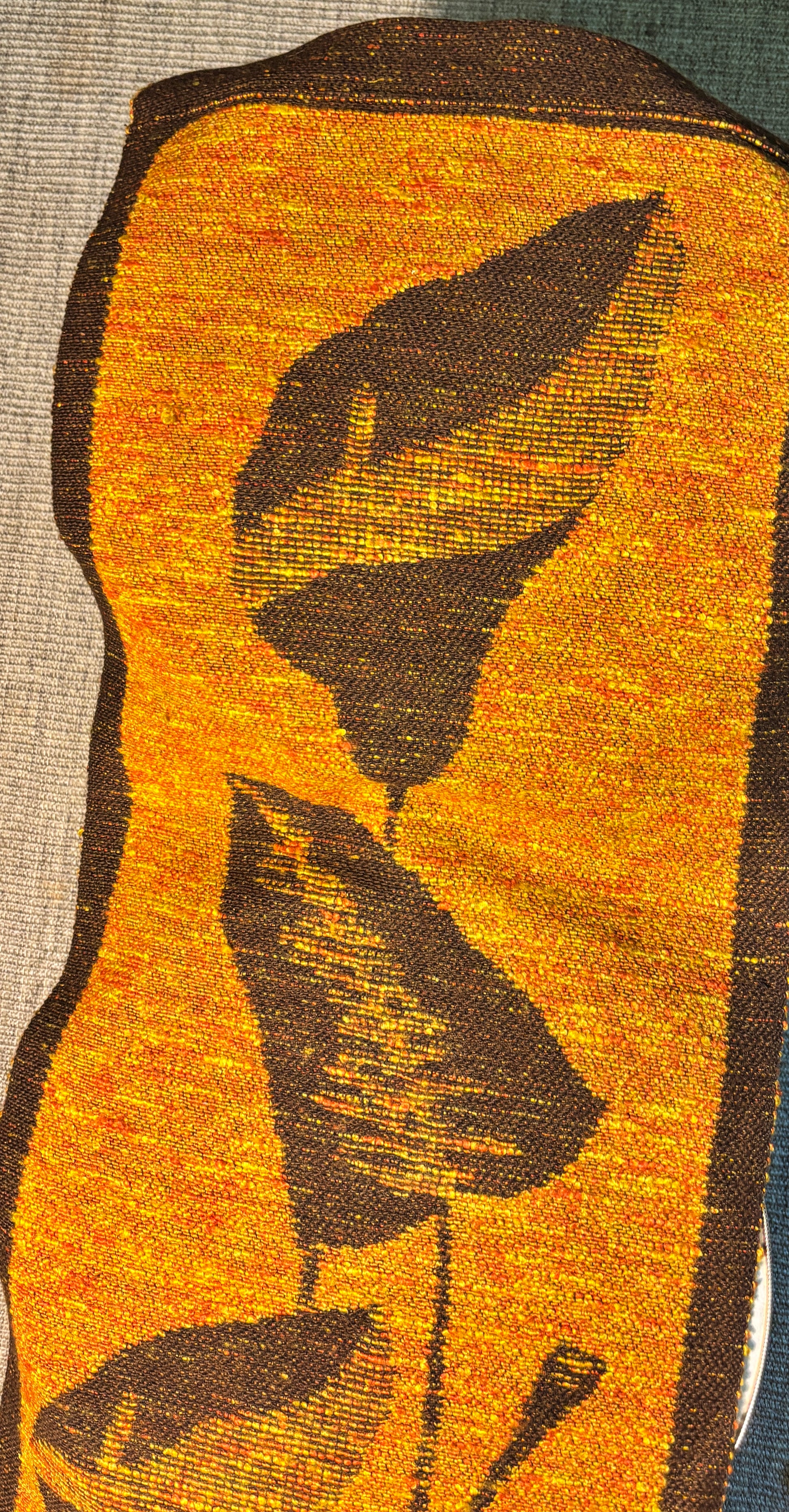 Textile with woven pattern of leaves on a yellow background