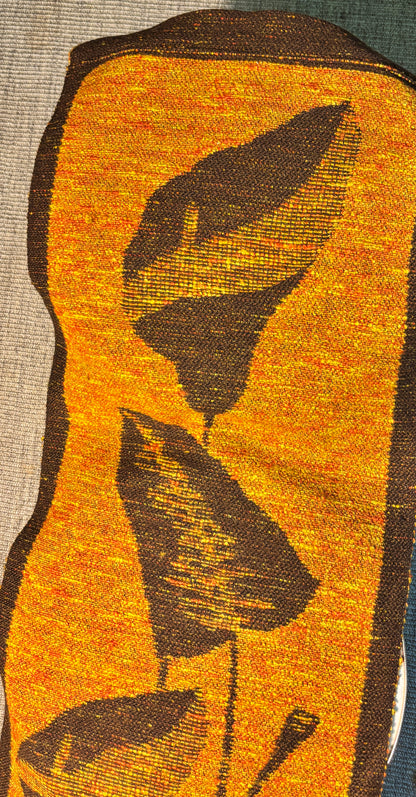 Textile with woven pattern of leaves on a yellow background