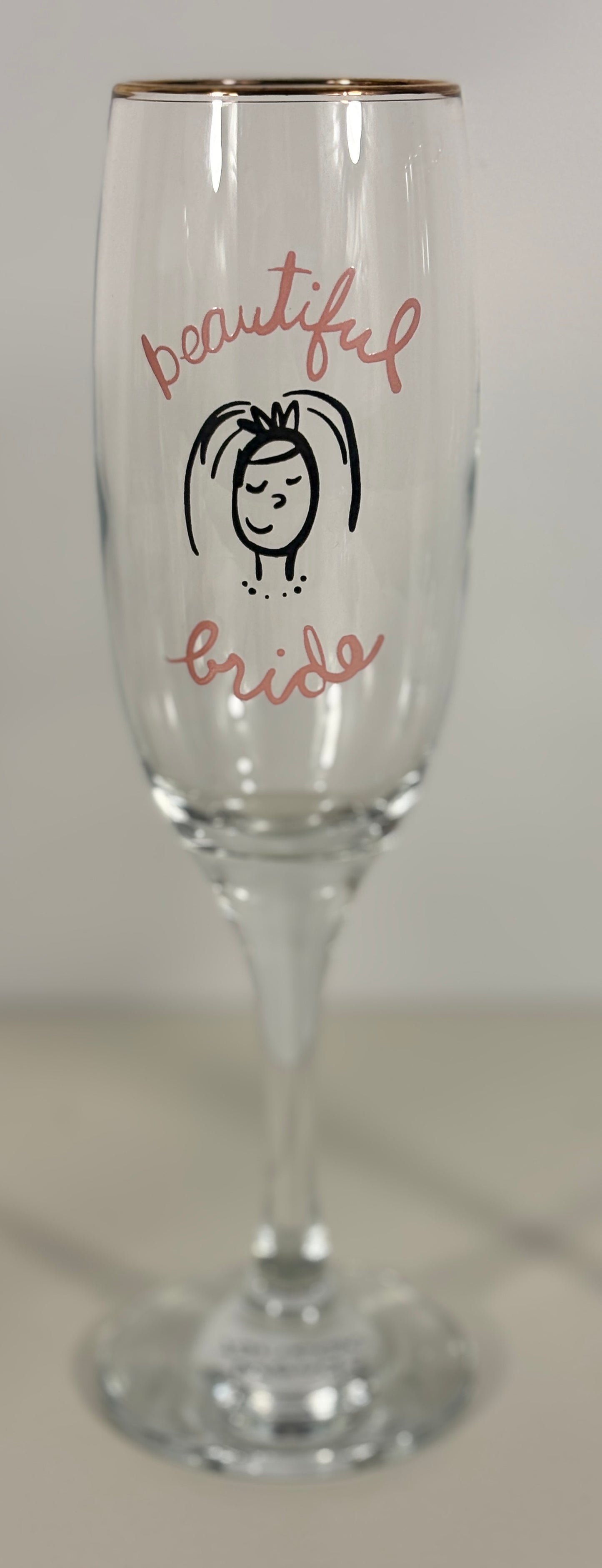 Champagne flute with 'beautiful bride' text and a small illustration on a white background