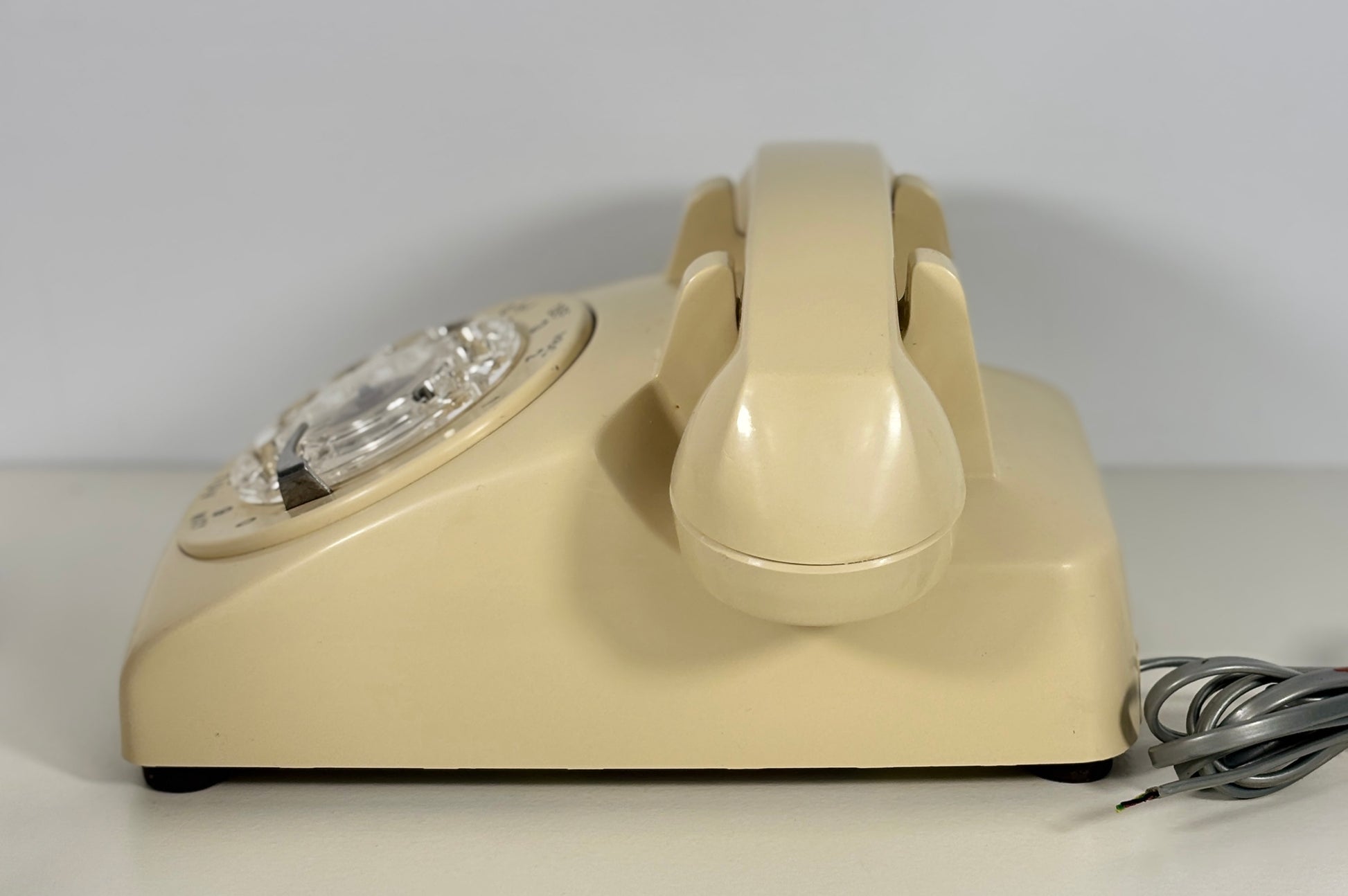 Beige rotary phone on a white background