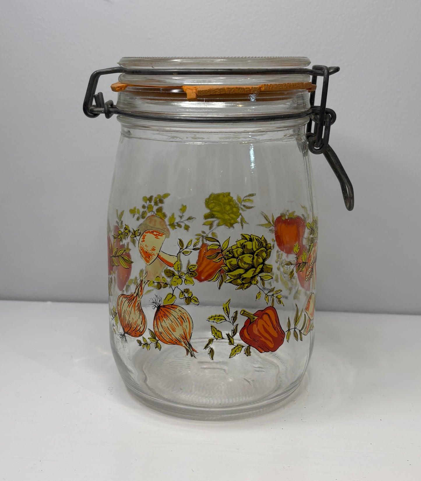 Clear glass jar with floral design on a white background