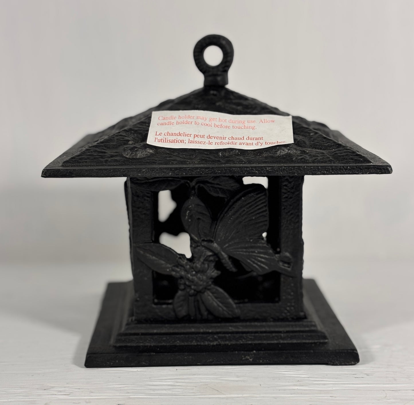 Black decorative lantern with butterfly design on a white background