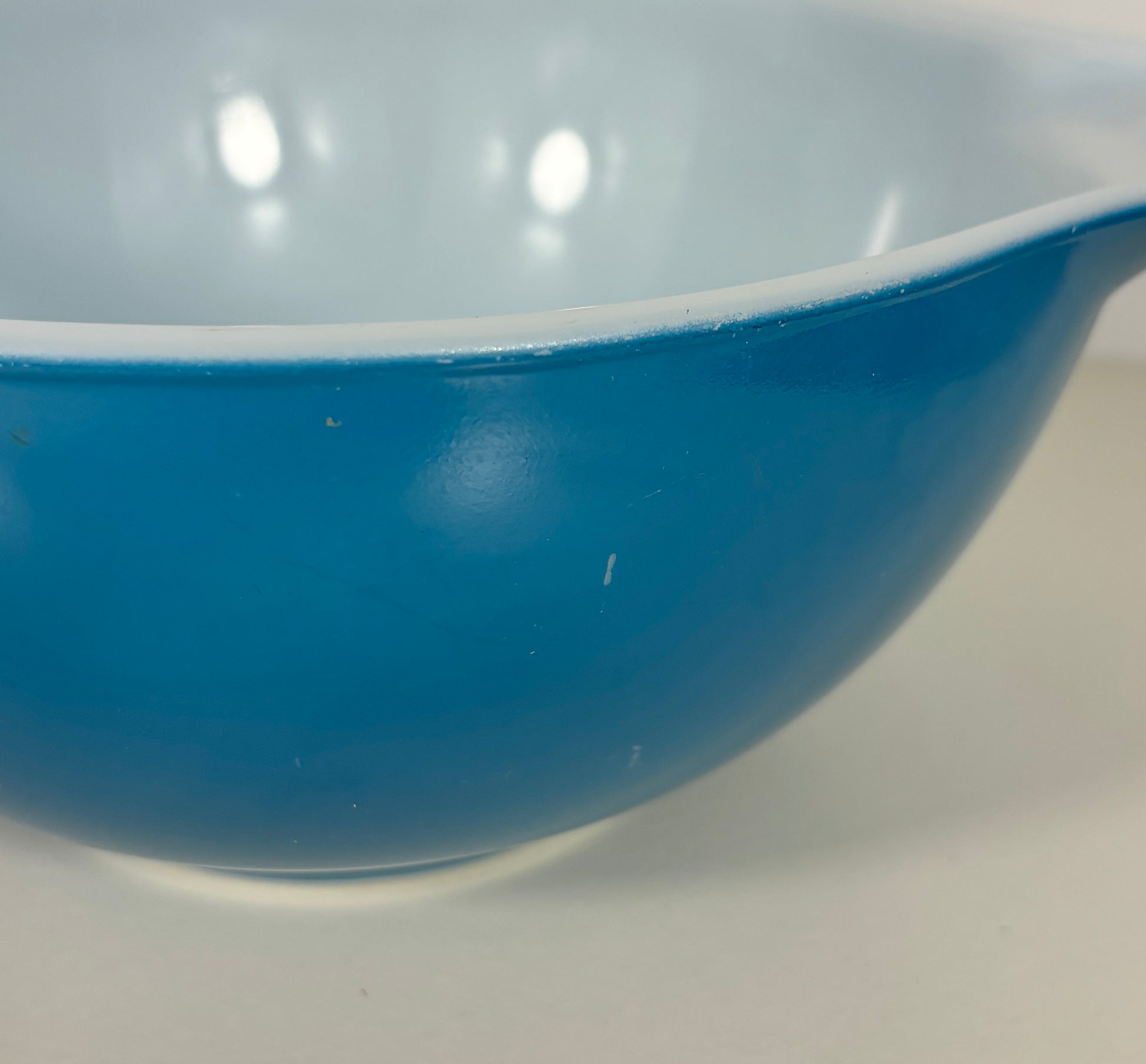 Blue bowl with white interior on a white background