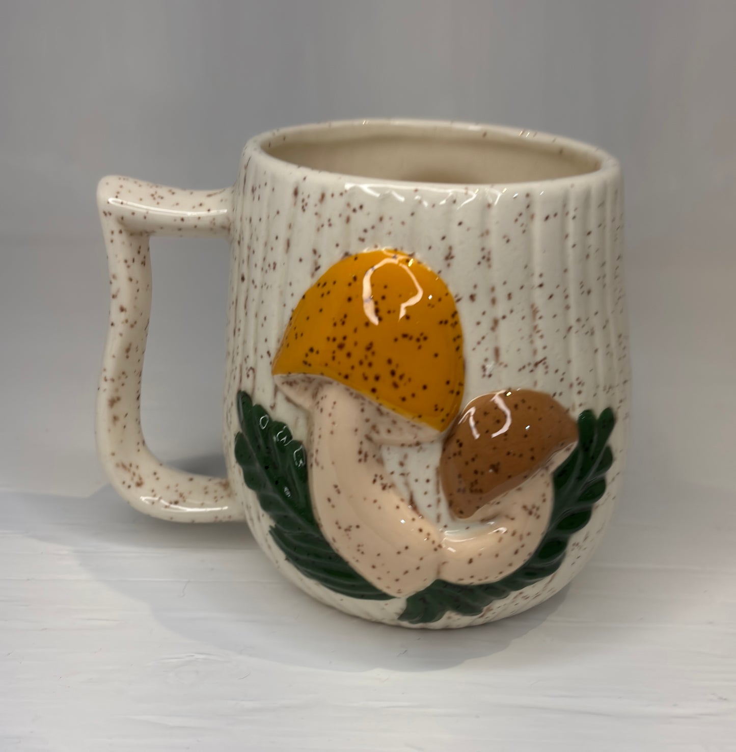 Ceramic mug with mushroom design on a gray background