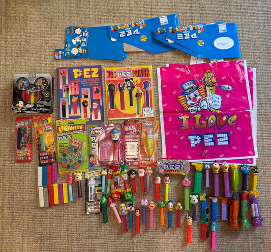 Collection of Pez dispensers and packaging on a textured surface