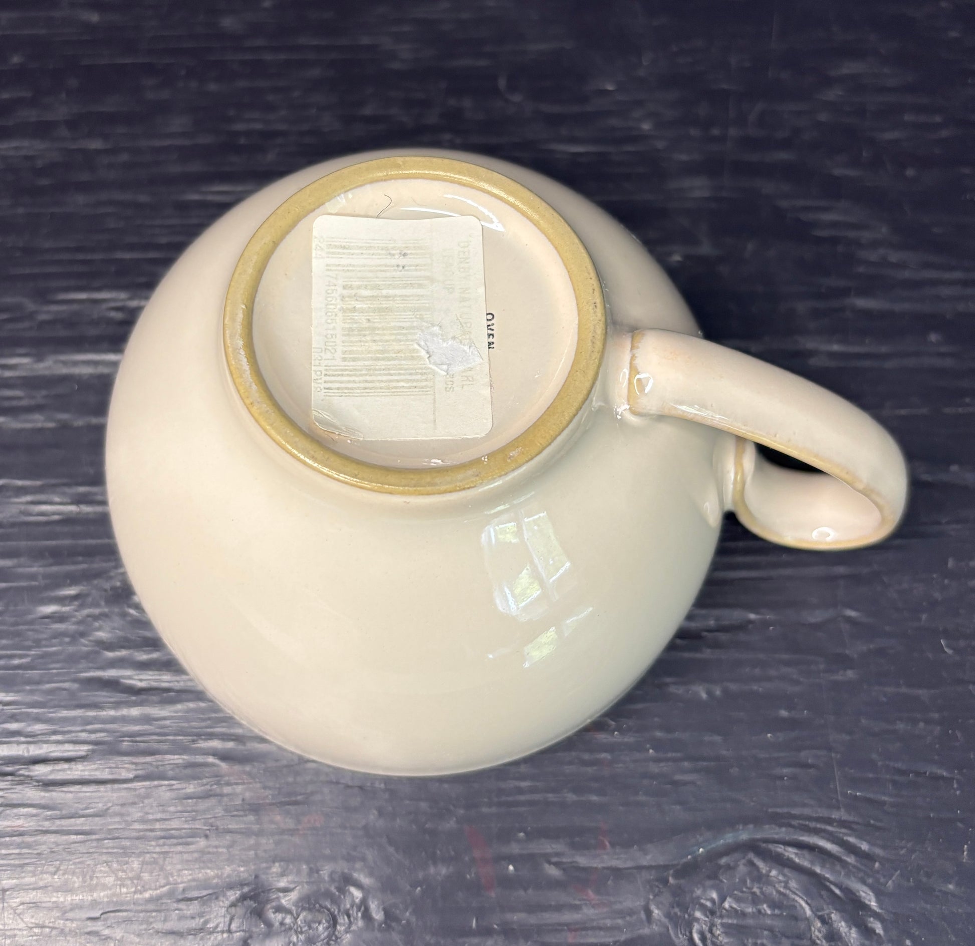 White ceramic mug with a beige interior on a dark textured surface