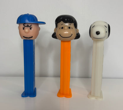 Three Pez dispensers shaped like cartoon characters on a white background