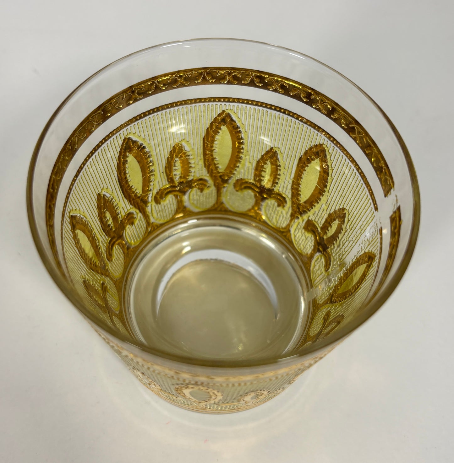 Decorative glass with gold patterns on a white background