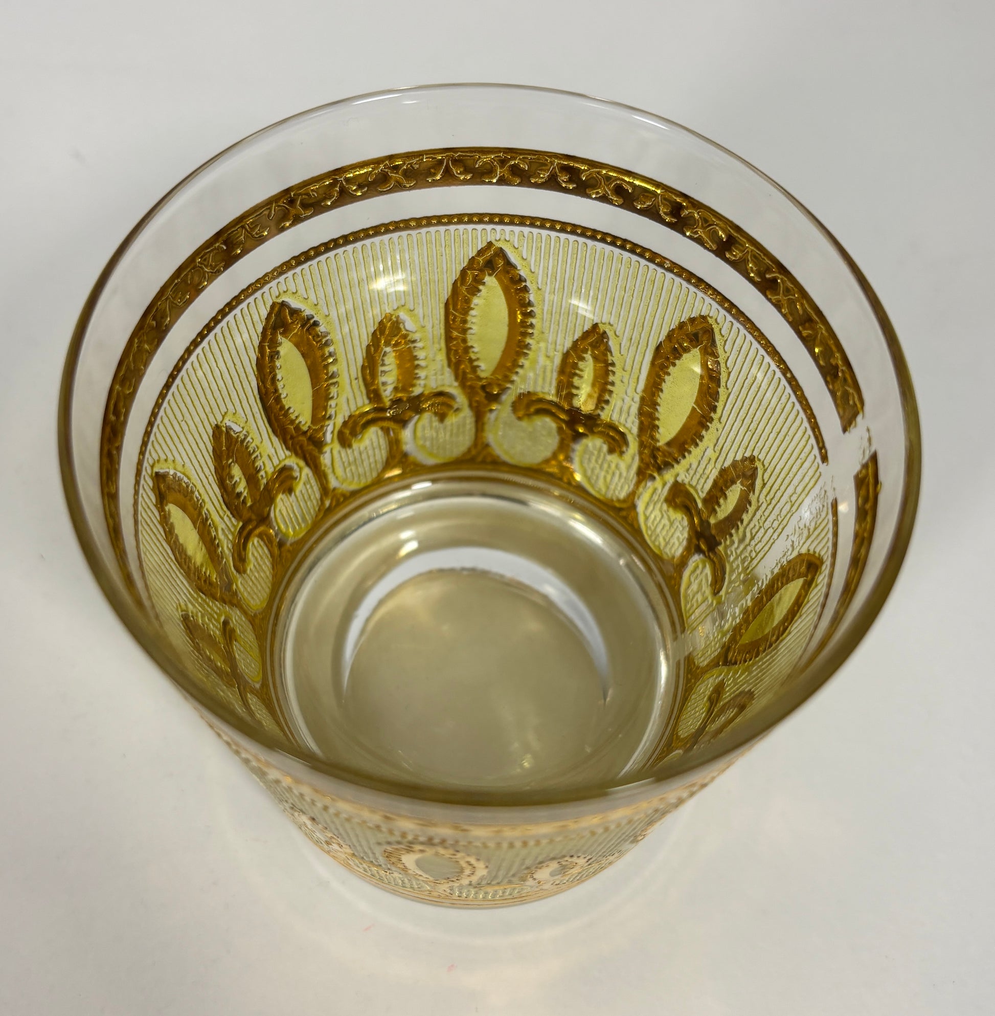Decorative glass with gold patterns on a white background