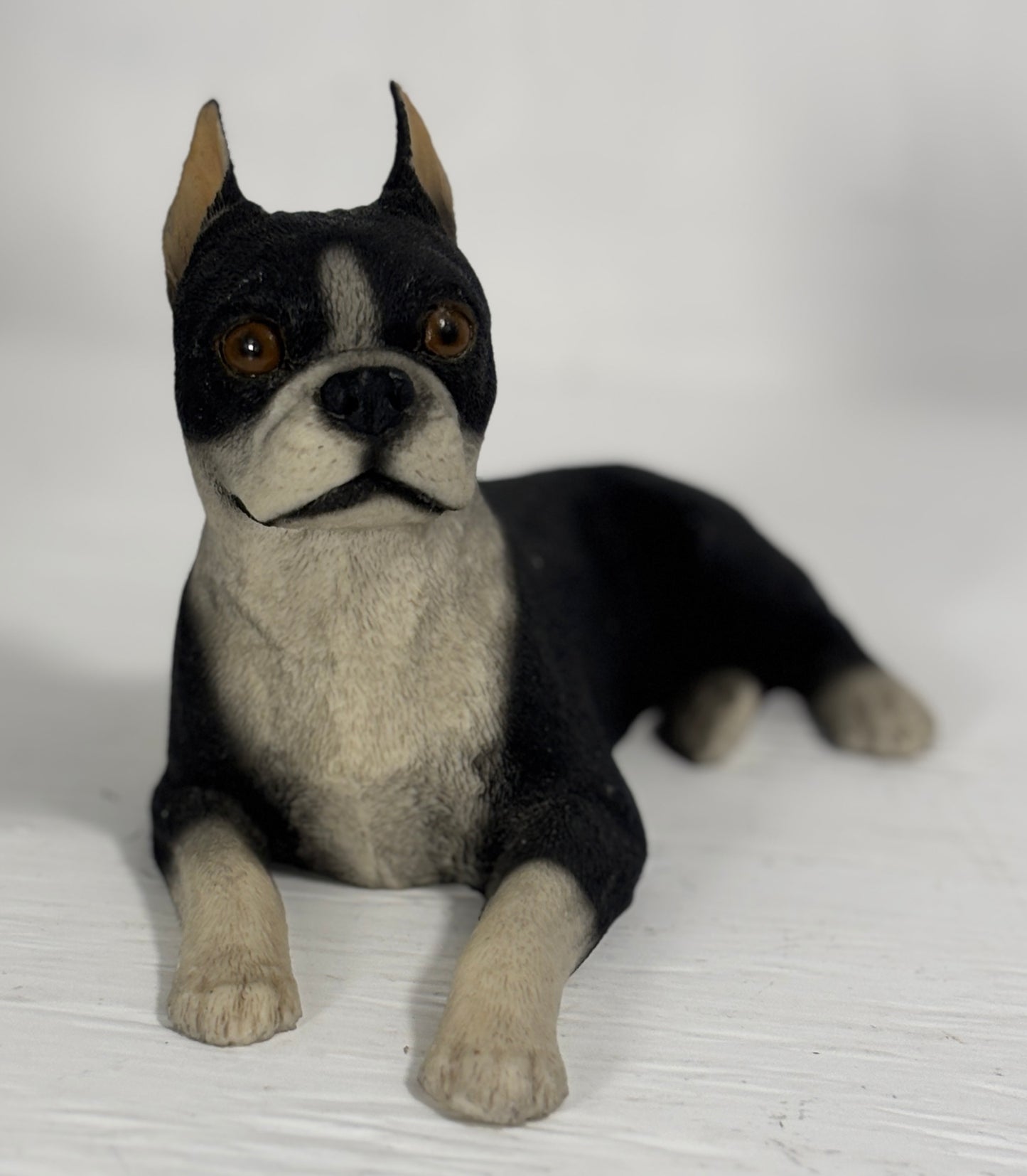 dog figurine with black and white fur on a white background