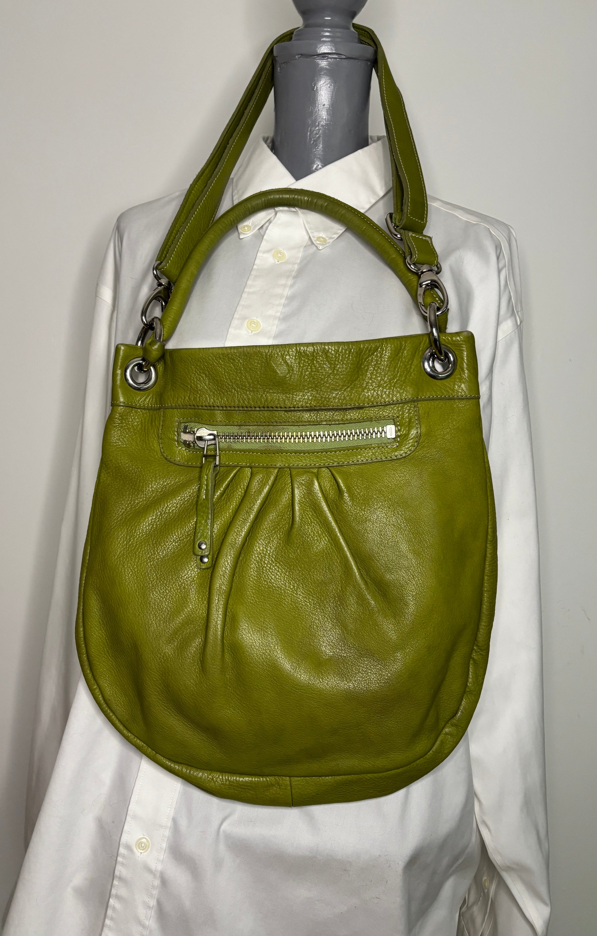 Green handbag on a mannequin with a white shirt