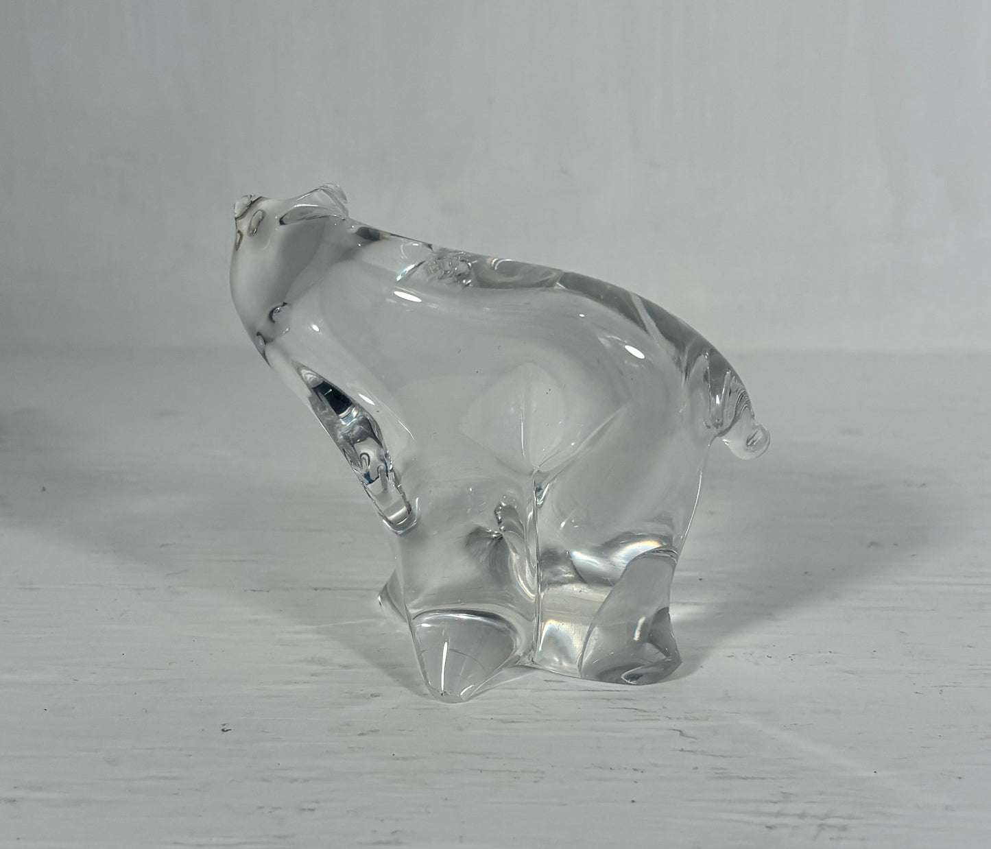 Clear glass bear figurine on a light wooden surface