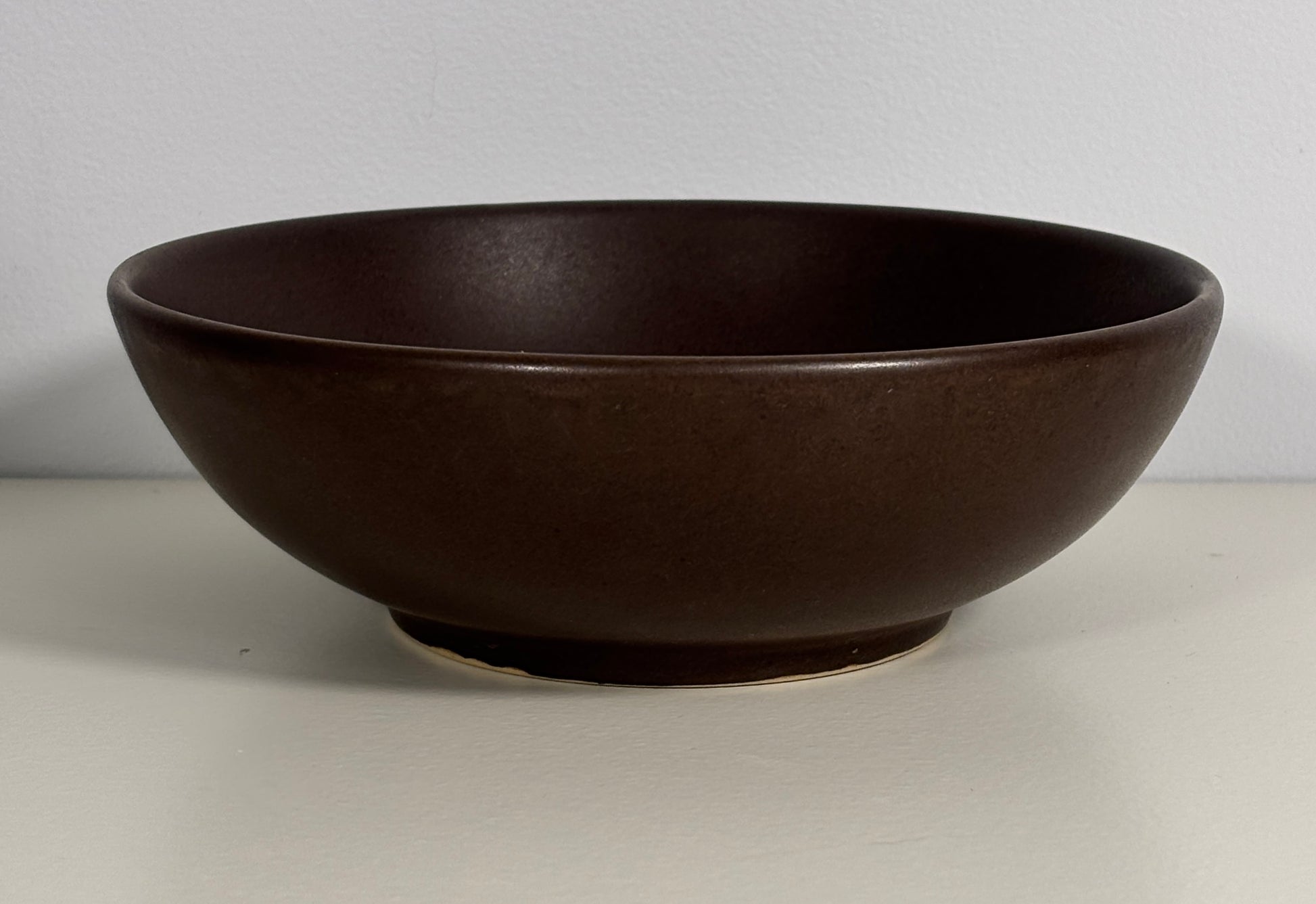 Brown ceramic bowl on a light gray background